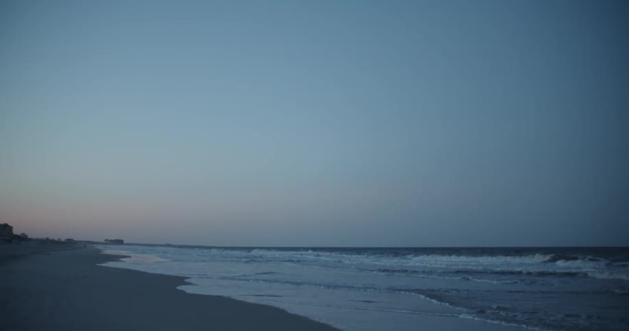 Ocean waves wash ashore at sunset