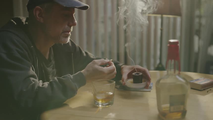 Smoke rises from the candle after he blows it out