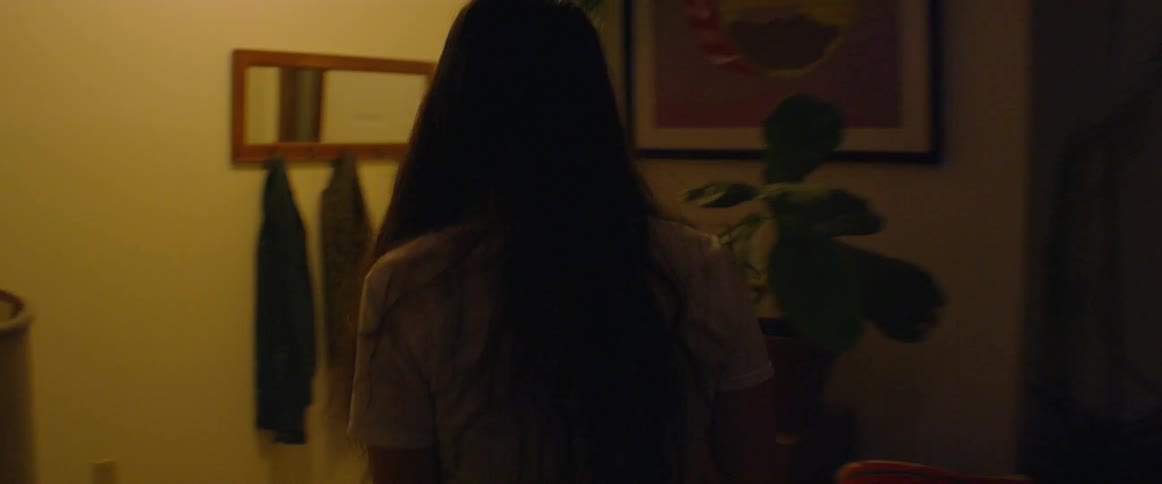 A woman walks to open the front door
