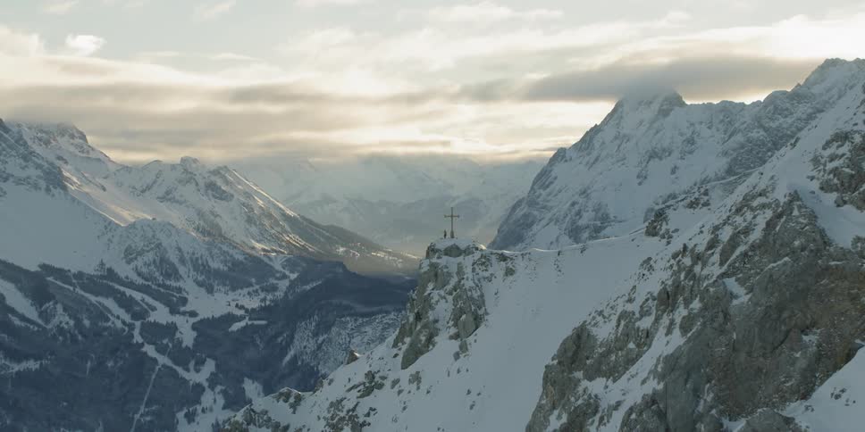 A cross on top of a snowy mountain