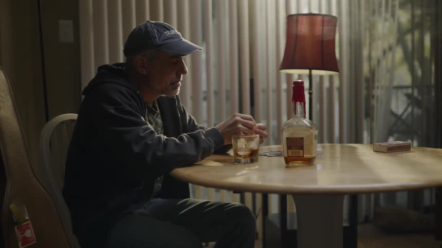 A man drinks alone at a table