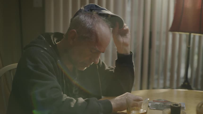 A man drinks alone at a table