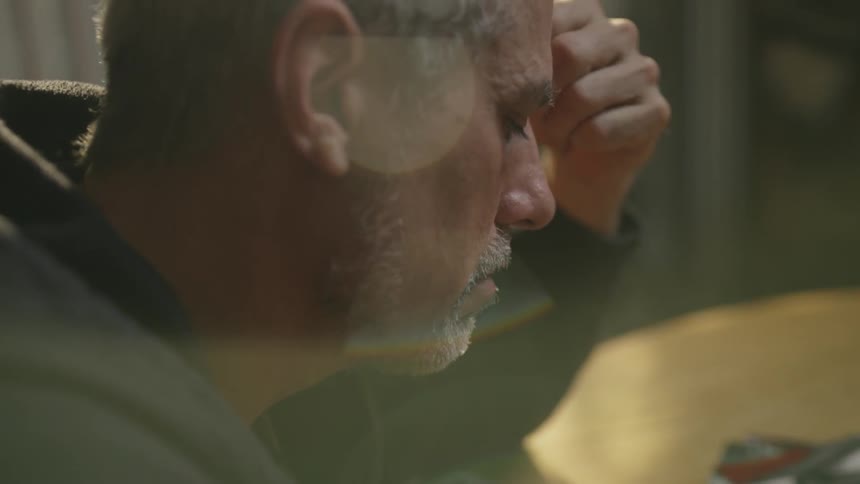 A man drinks alone at a table