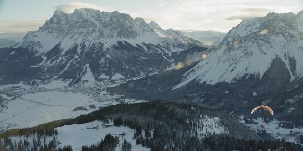 Parachute floats over a snowy forest