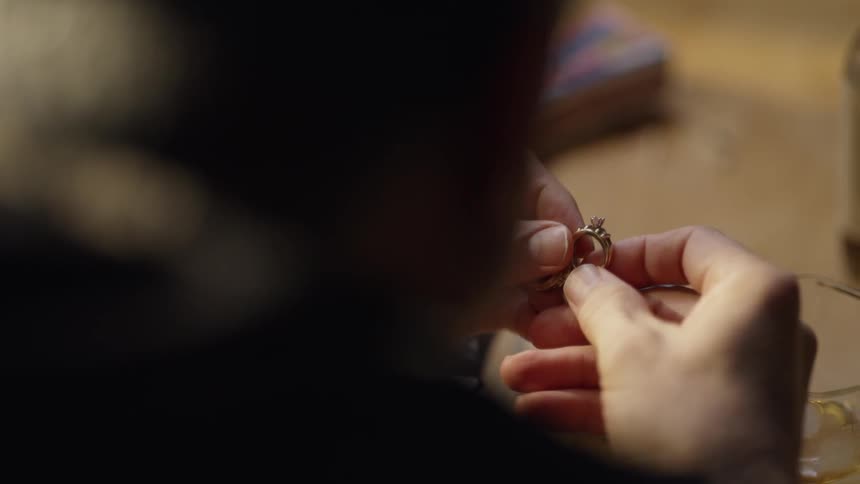 A man examines a ring at the table