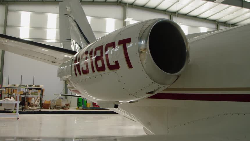 The plan is parked in the hangar on a sunny day