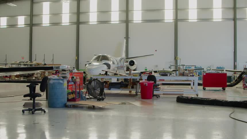 The plane is surrounded by tools and barrels