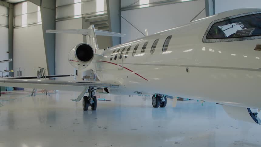 The white plane is parked in the hangar
