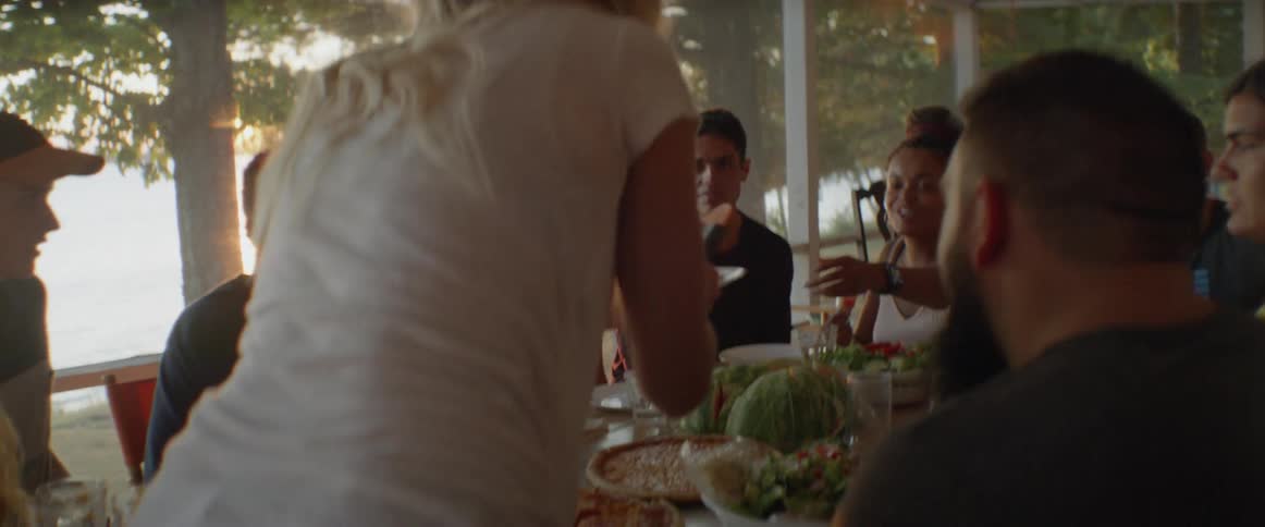 Food is being served at a table full of people