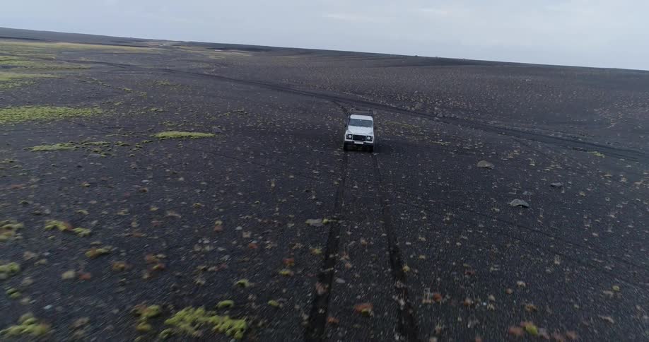 The vehicle drives through the dark dirt