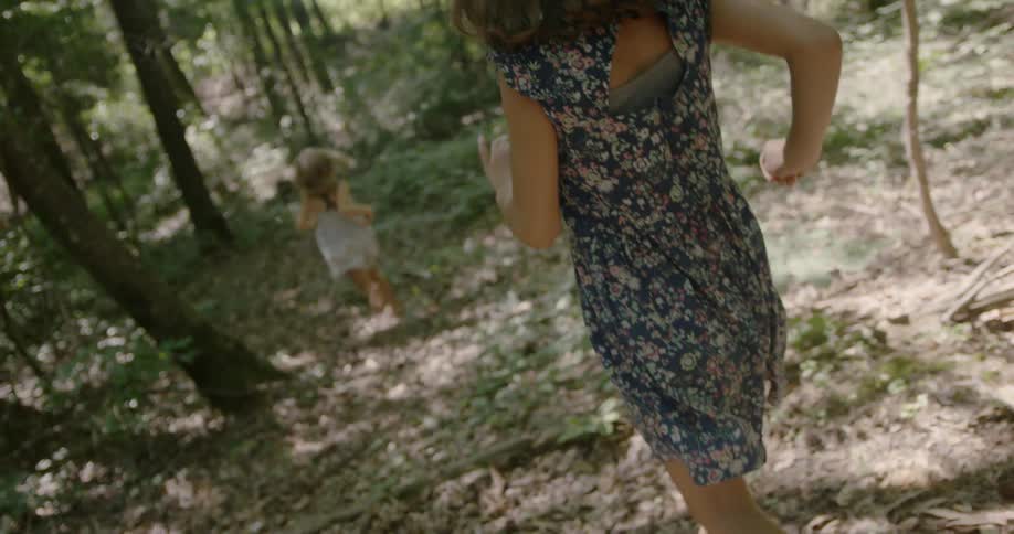 Girls chasing and playing in a wooded area