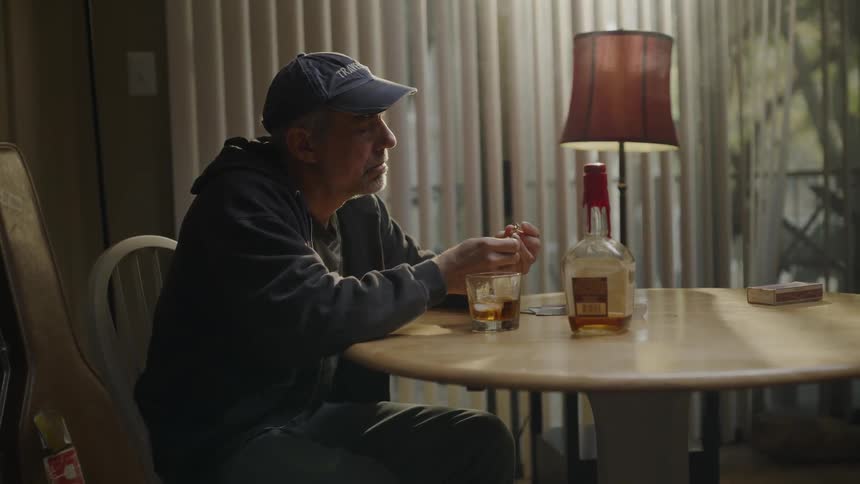 Man sits at a table drinking alcohol