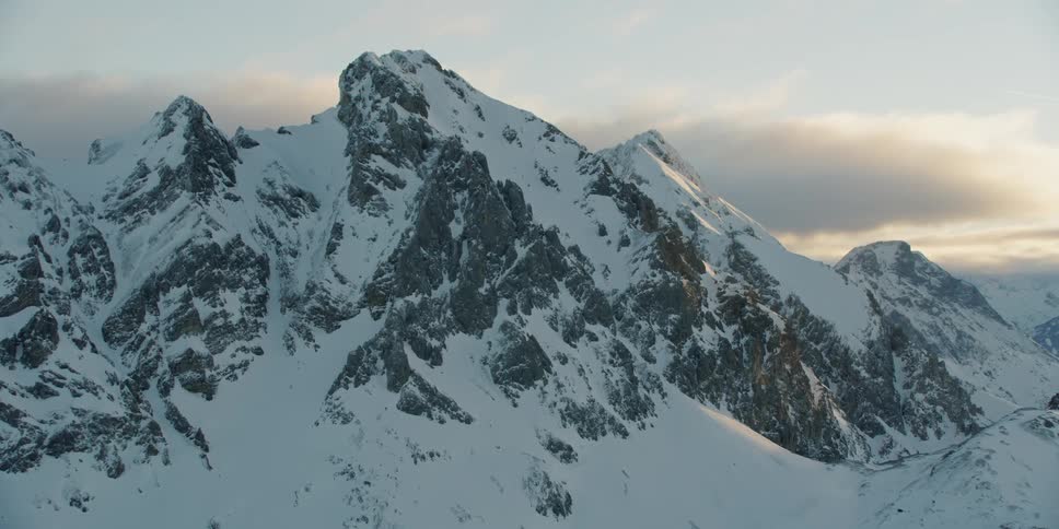 Snow-covered mountains at a somewhat cloudy sunset