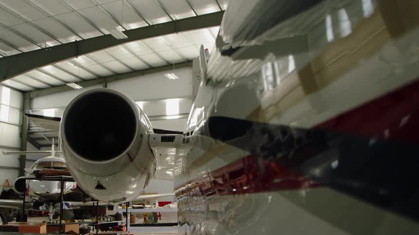 A private airplane is sitting idle in a hangar in daylight