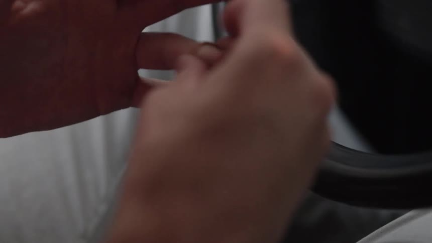A man places a small gold ring on his finger then drives