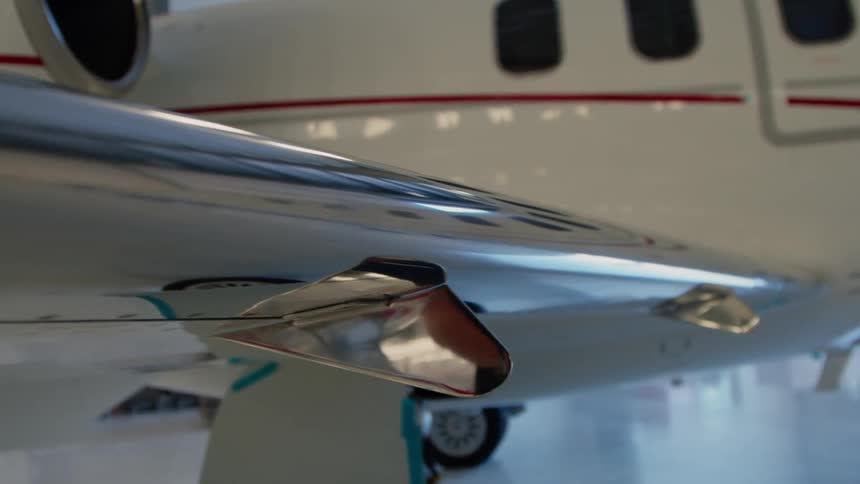 The surface of an airplane wing reflects its surroundings