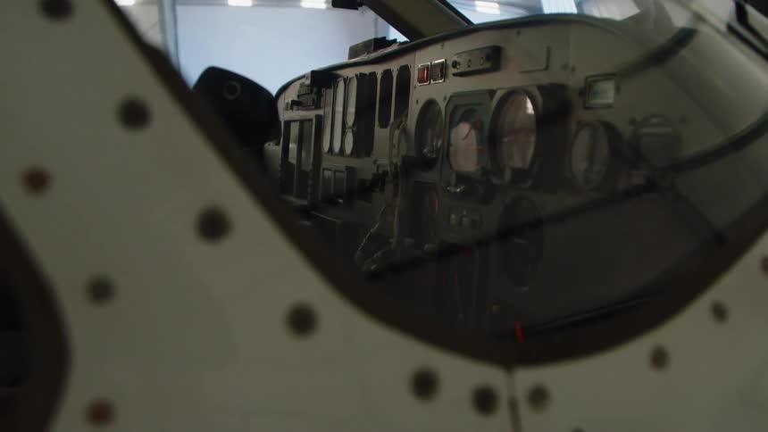 The cockpit of an airplane parked in a hangar