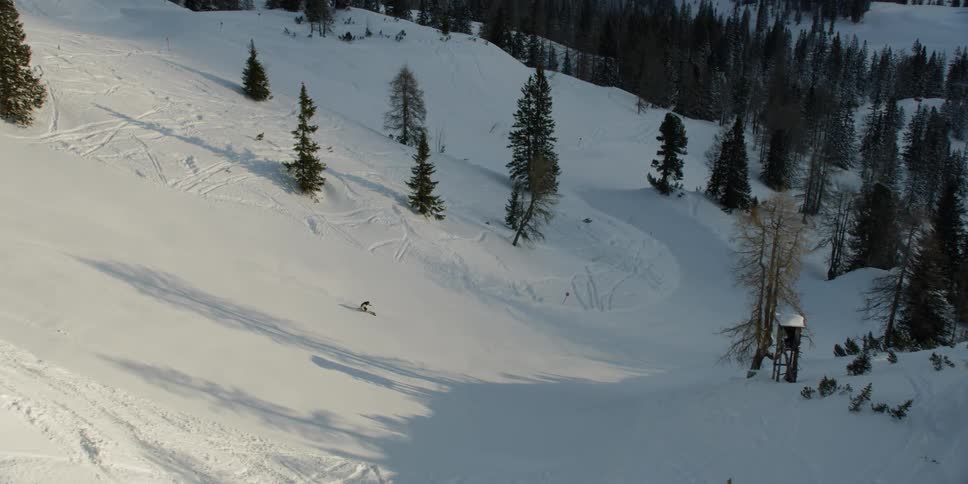 Person skiing down snow covered mountain slope