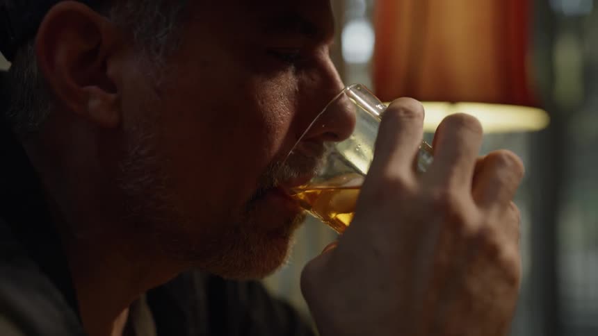 Man looks sad while drinking whiskey
