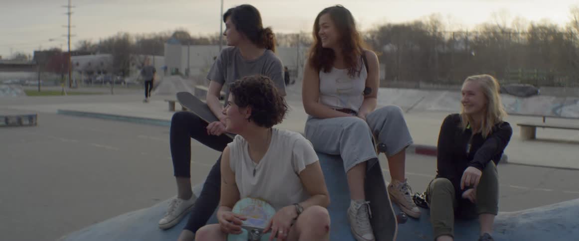 A group of people sit in the skate park together
