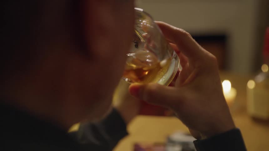 Man sits at a table drinking alcohol