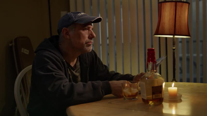A man drinks alone at a table