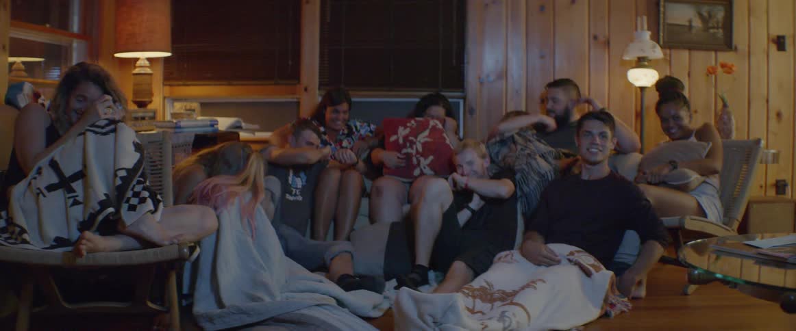 A group of people sit together and watch a movie