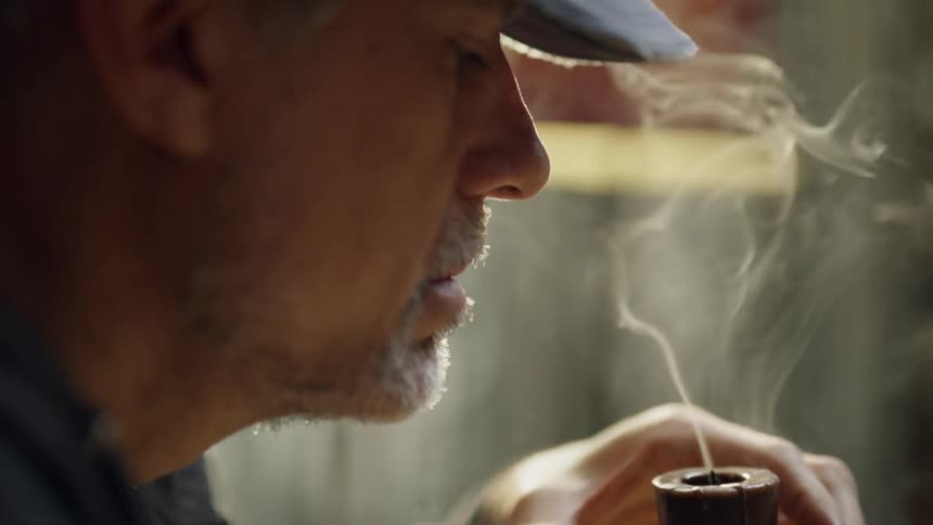 A man blows out a small candle