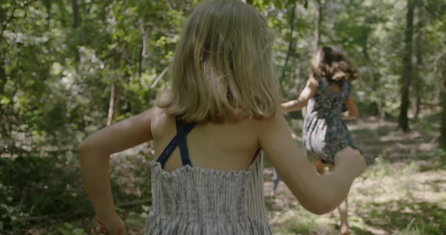 Little girls are running through a forest