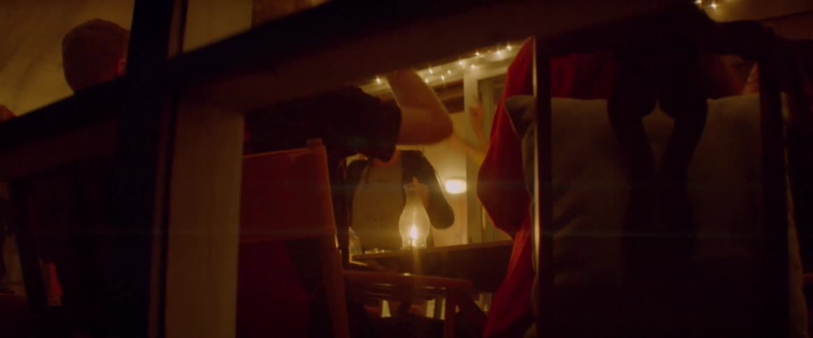 People play a card game on the porch at night