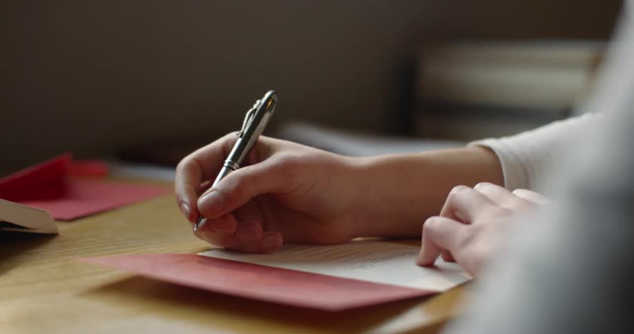 Person writing on a greeting card