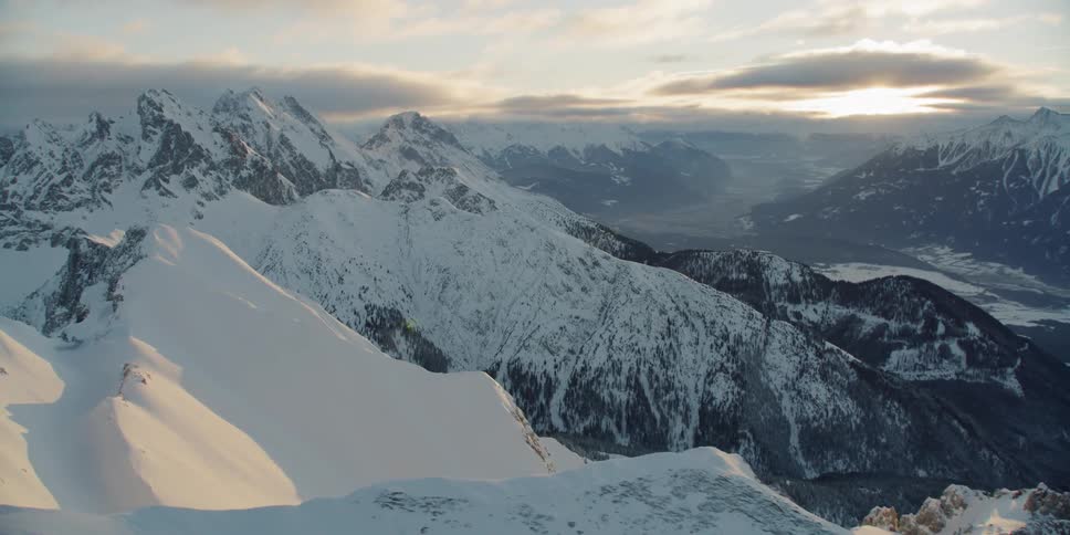 Now covered mountains sit under a cloudy blue sky
