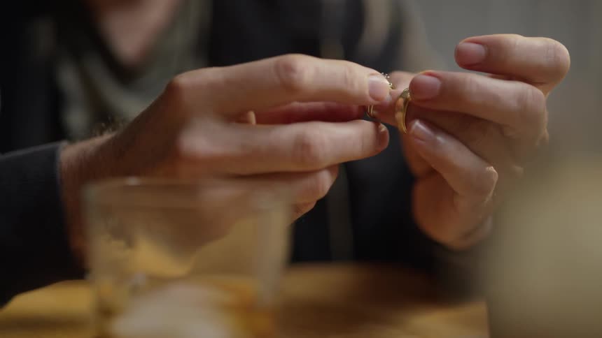 Person holding two rings near a glass