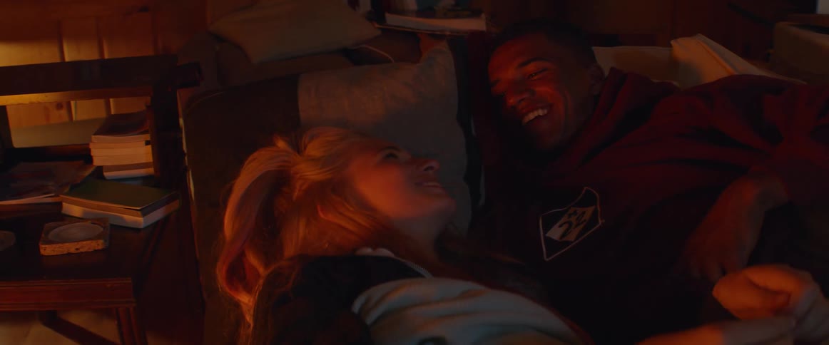 A couple talk and lay together in bed