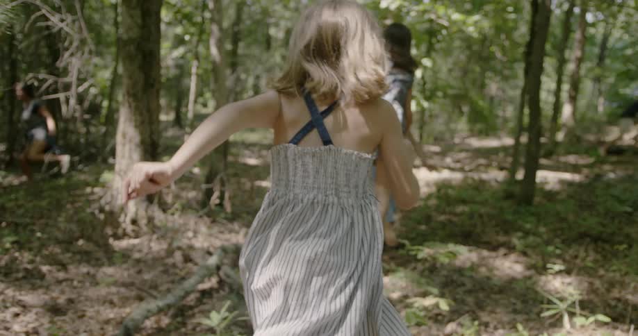 Girls run through a forest