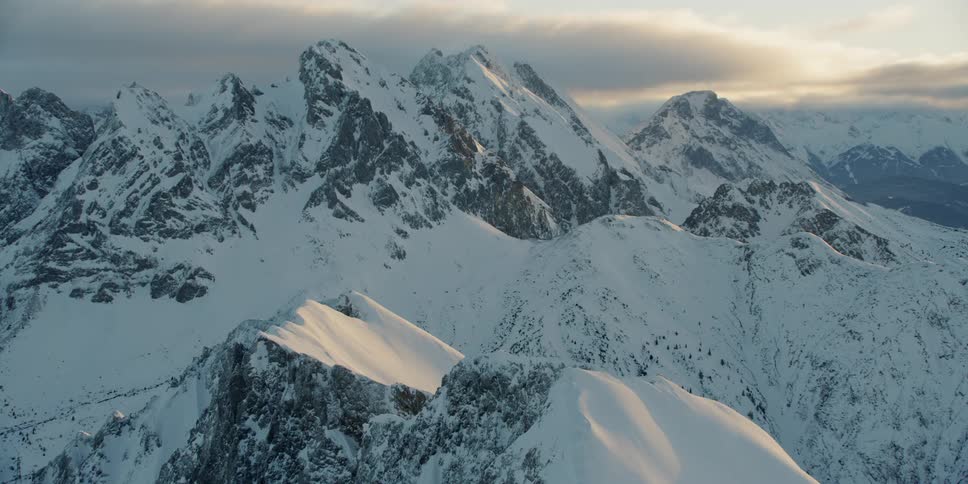 The sun is setting behind the large mountain range