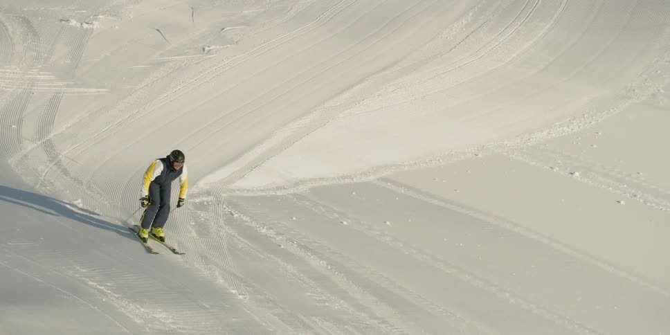 Man skis down a large ski hill