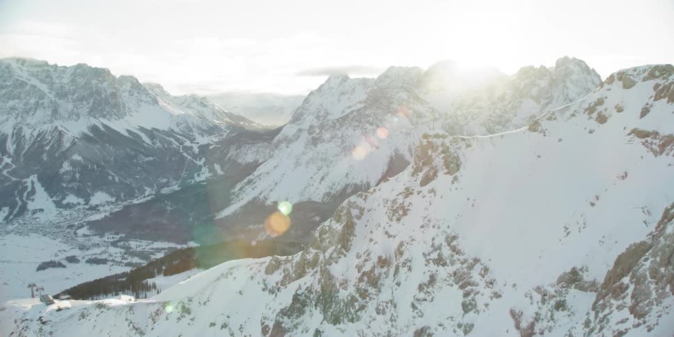 Sun shines down over snowy mountains