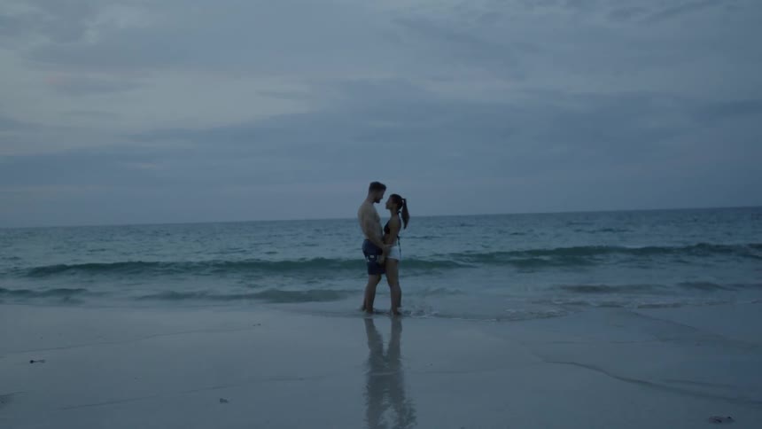 A couple hug by the water