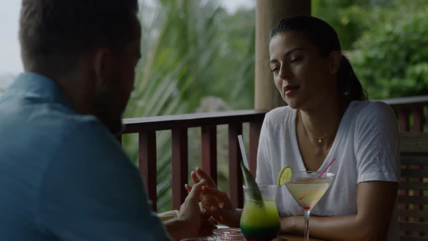 A couple hold hands while sitting at a table