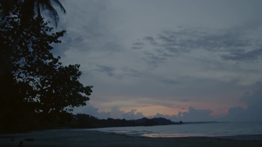 The sun is setting on the shore