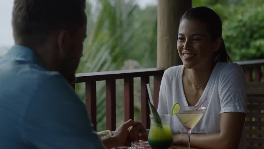 A man and woman talk on the patio outside