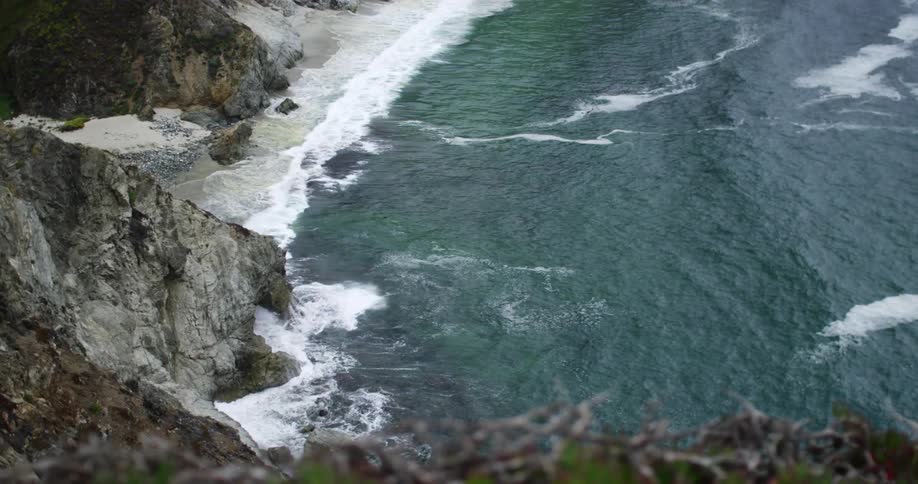 Waves are crashing on the shore of Big Sur
