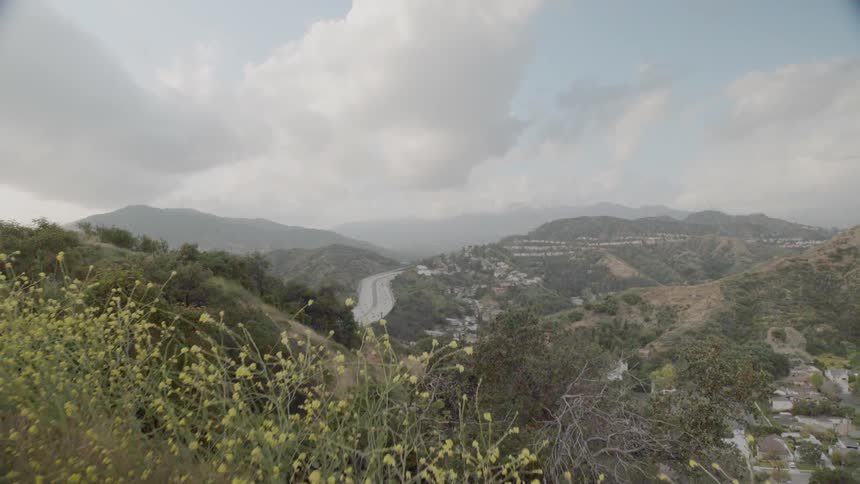 Green hills lead to a highway below