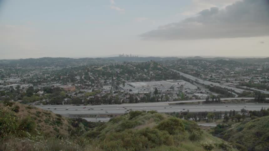 Traffic is flowing on a freeway system during the day