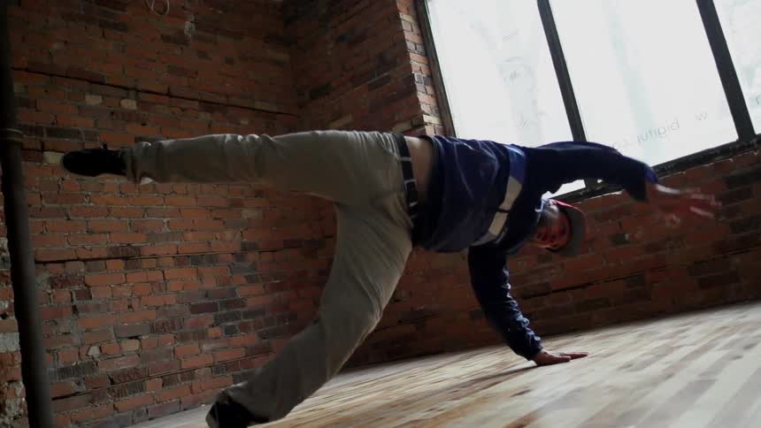 Man break dancing by a window inside