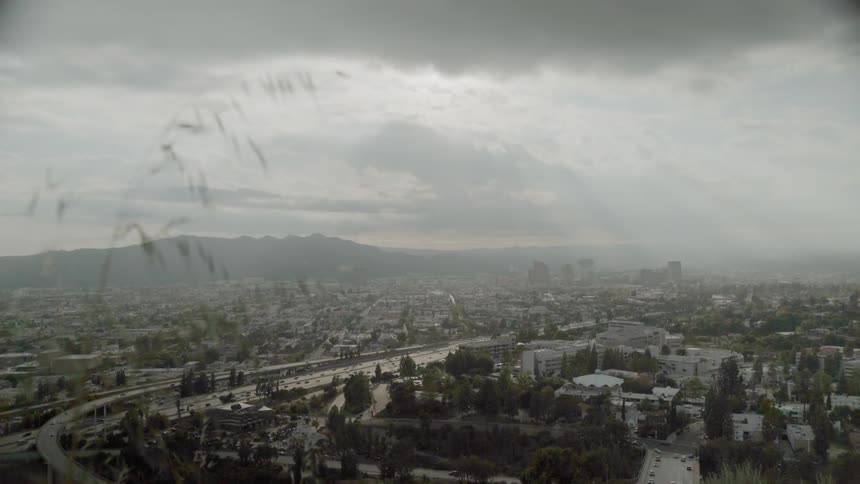 Traffic is flowing on a freeway system during a stormy day