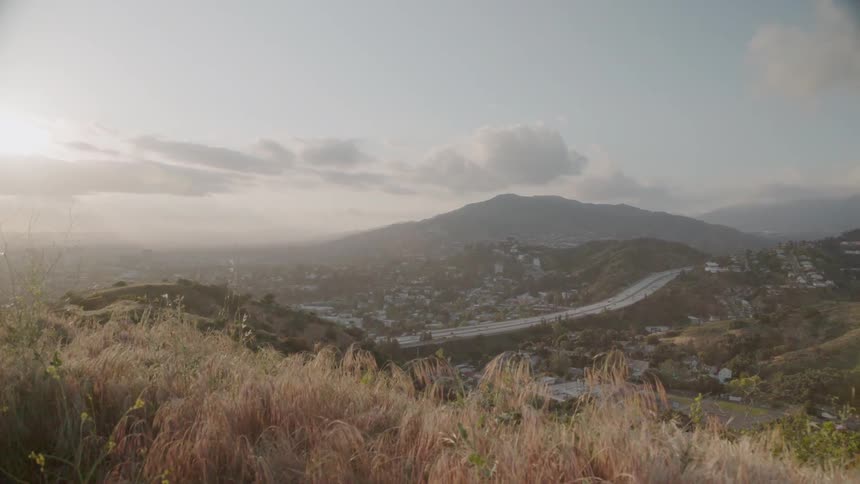 The sun sets over hills