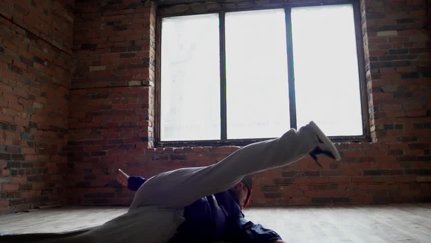 A man is breakdancing indoors