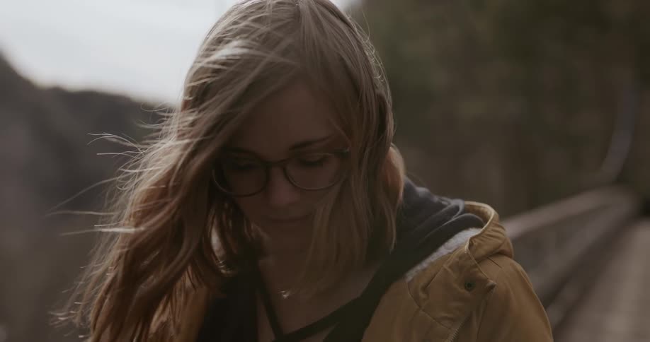The woman looks down on a windy day